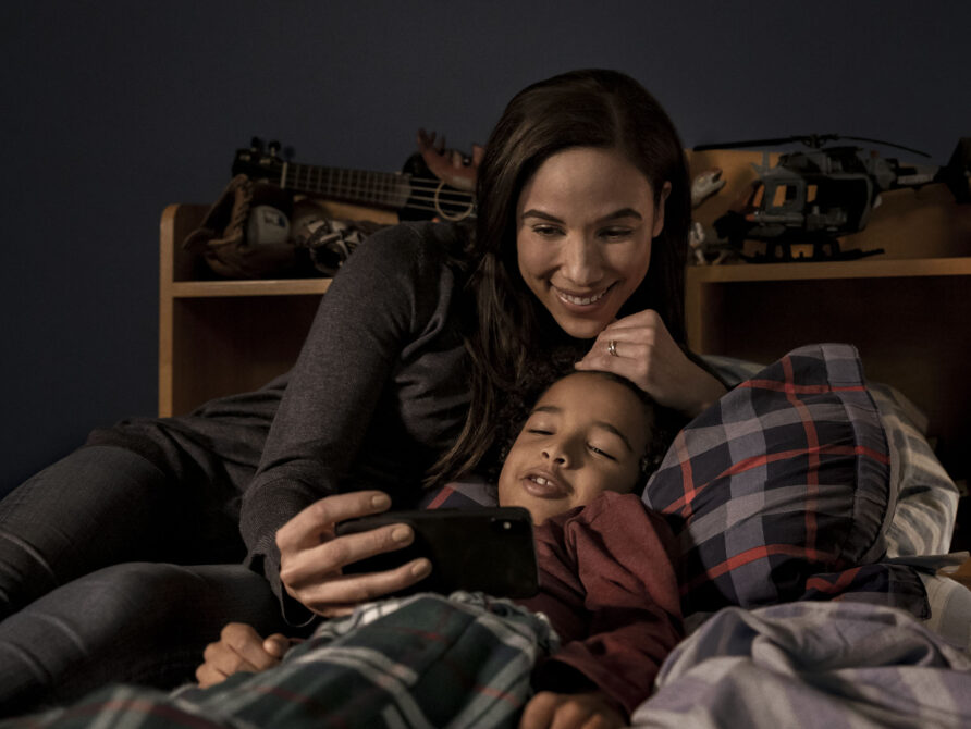 Mother and son talking to doctor via telehealth app.