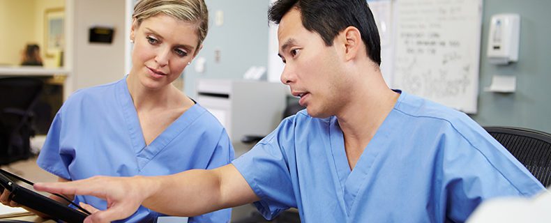 Two nurses looking at EHR tool on computer.