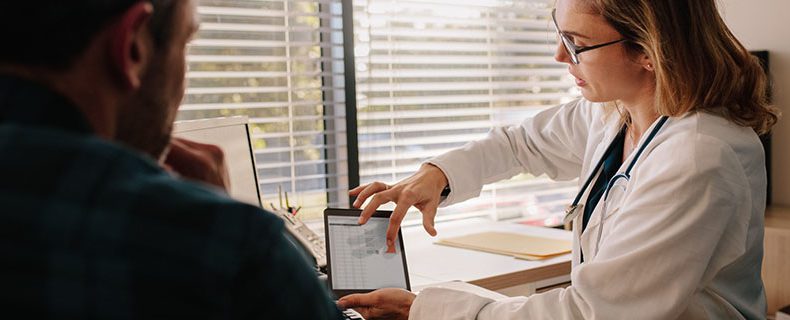 Doctor using electronic health record (EHR) tool on tablet.