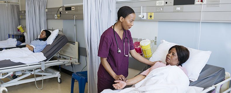 Nurse with patient at bedside.