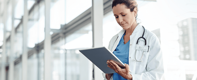 Doctor using EHR app on tablet.