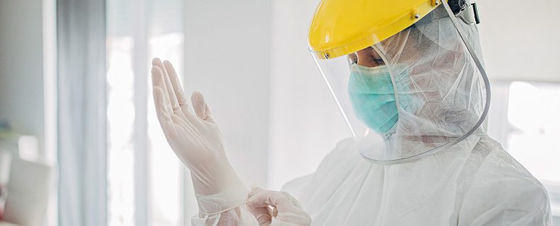 Female doctor in full protective suit in home inspection.