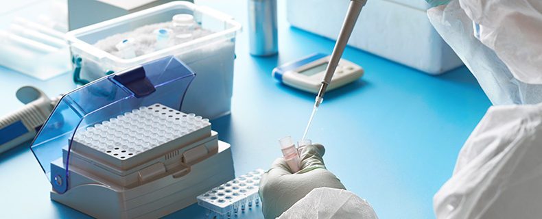 Epidemiologist in protective suit works with patient swabs.