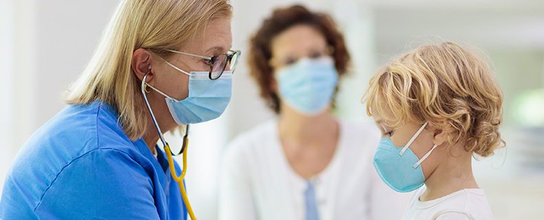 Doctor examining sick child in hospital.