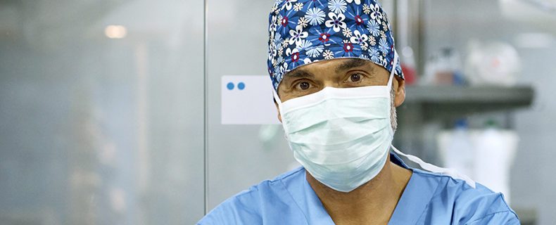 A surgeon wearing a surgical mask to protect face.