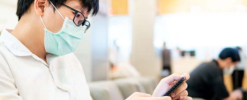 Male patient using smartphone in hospital.