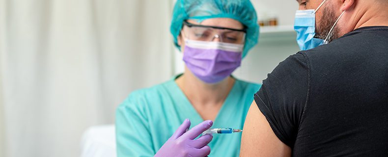 Doctor giving patient flu shot.