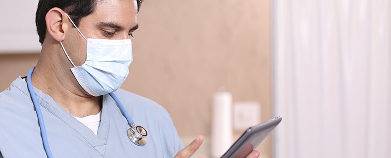 Doctor using EHR app on tablet.