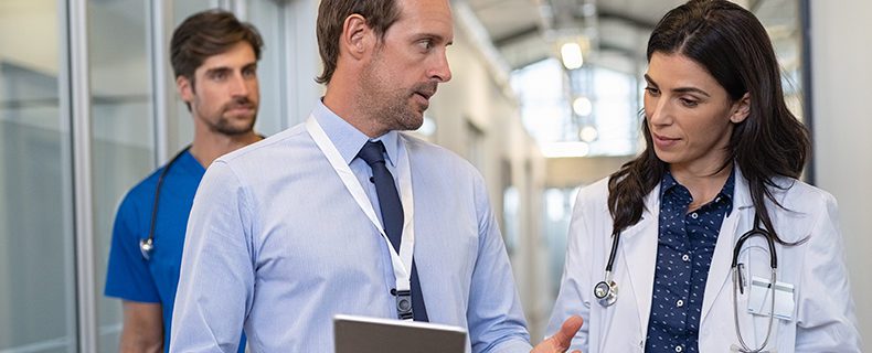Two doctors and nurse in conversation about patient information.