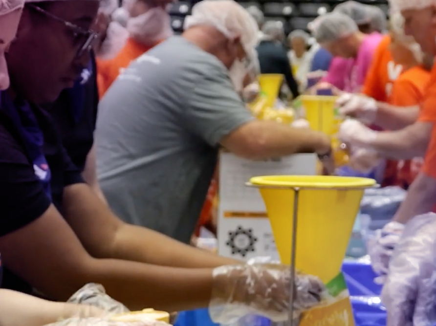 Individuals in a line wearing gloves