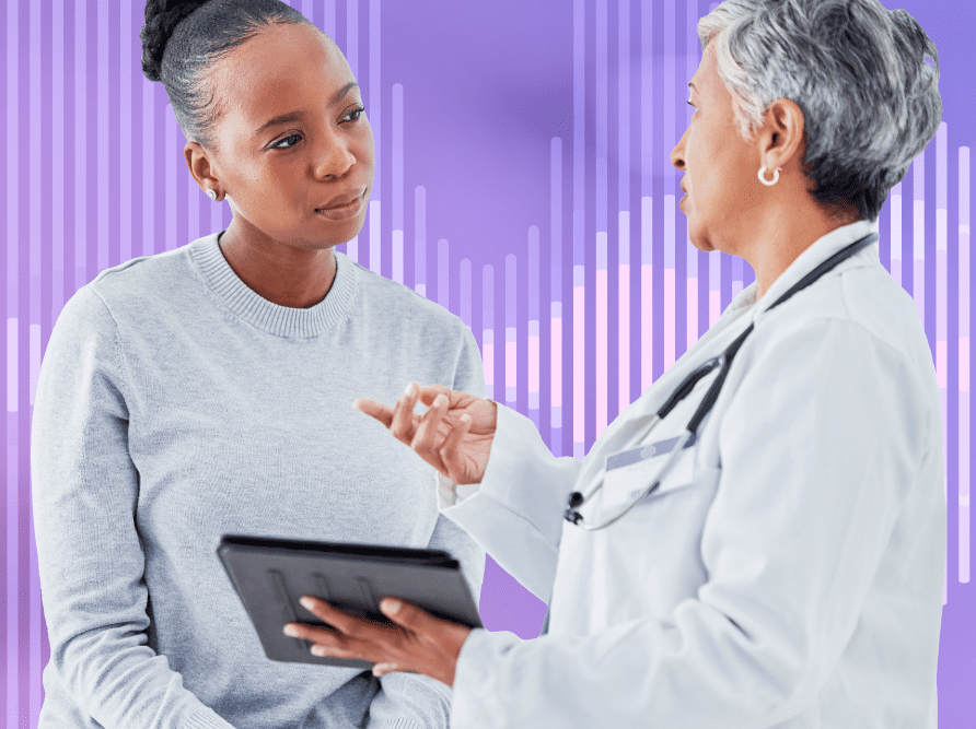 Doctor holding tablet with EHR software conversing with patient